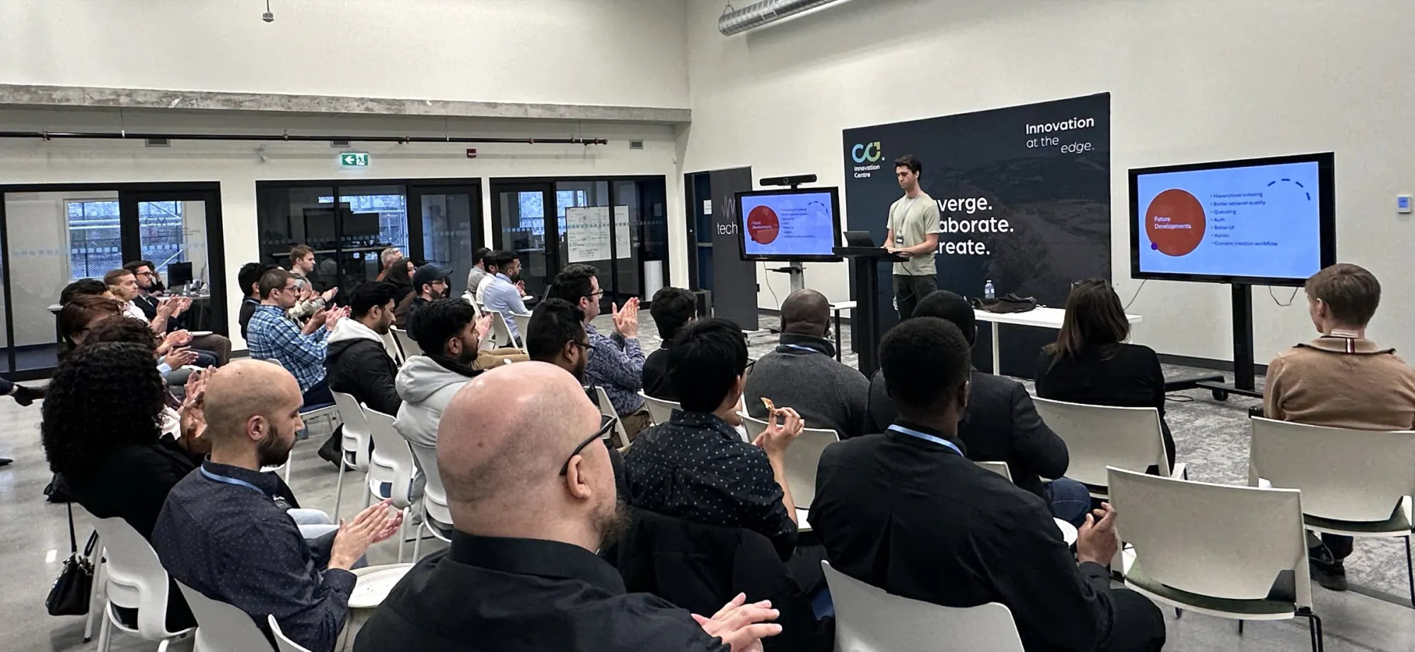 A full room applauding at the close of a Get Building training program