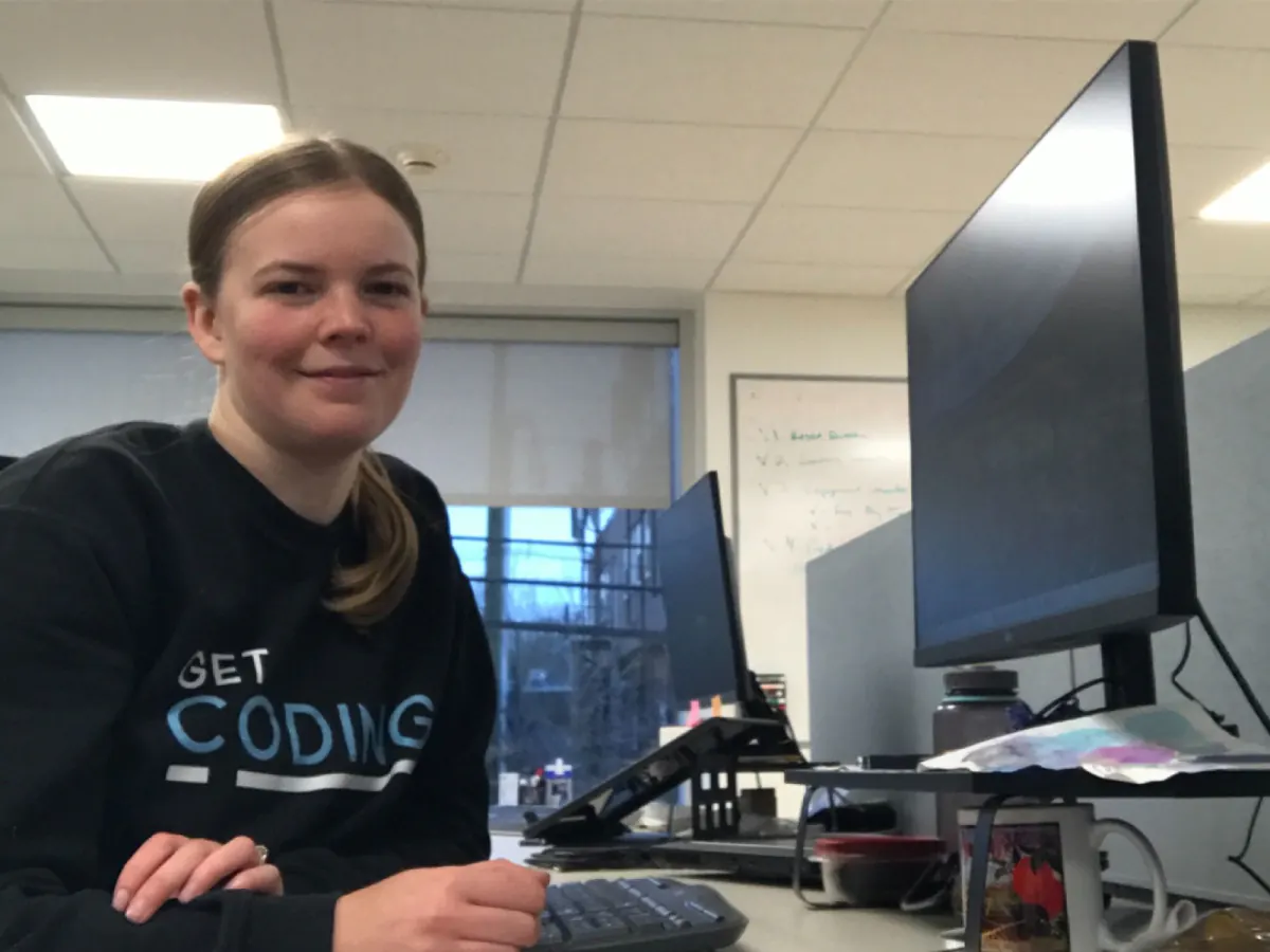 Isabel McIlroy at her desk in a Get Coding sweater