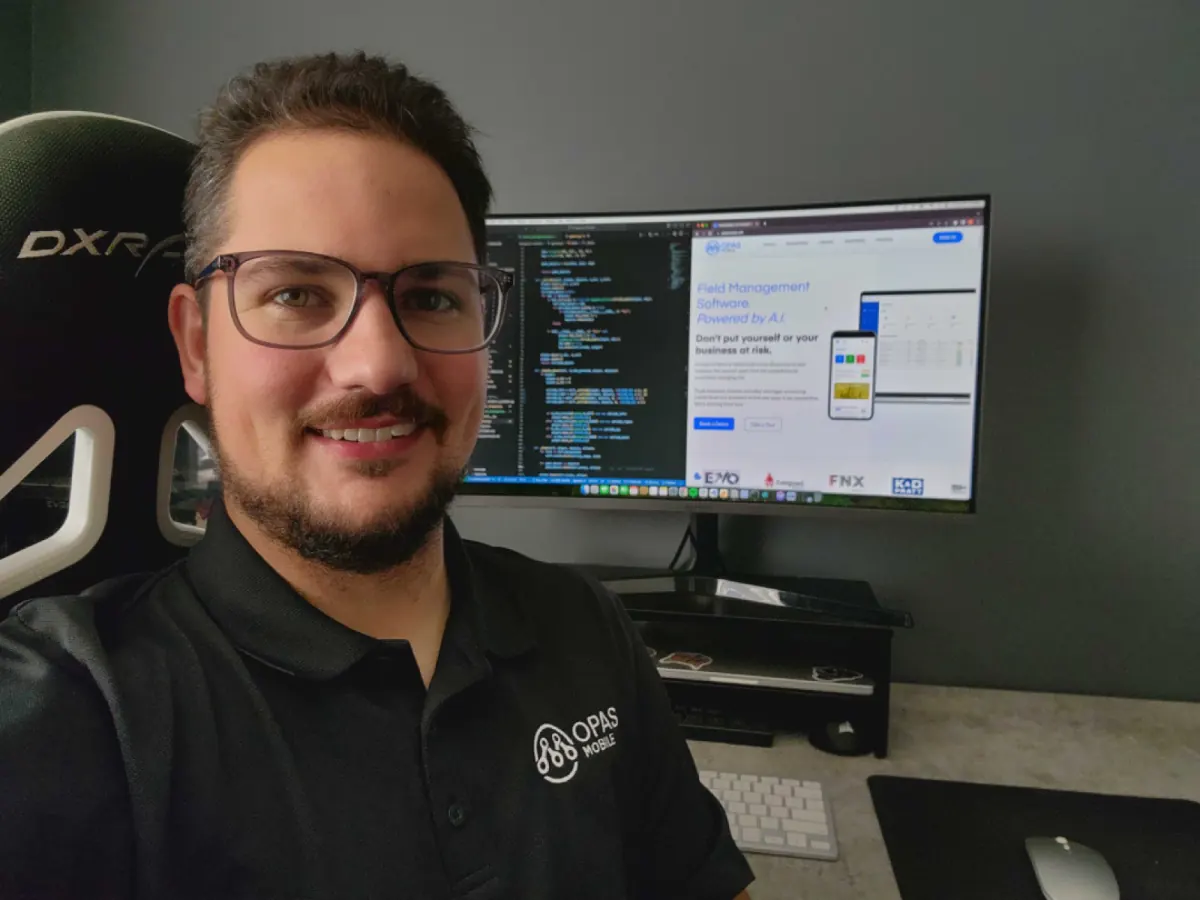 Matthew Vey at his desk with code on his monitor